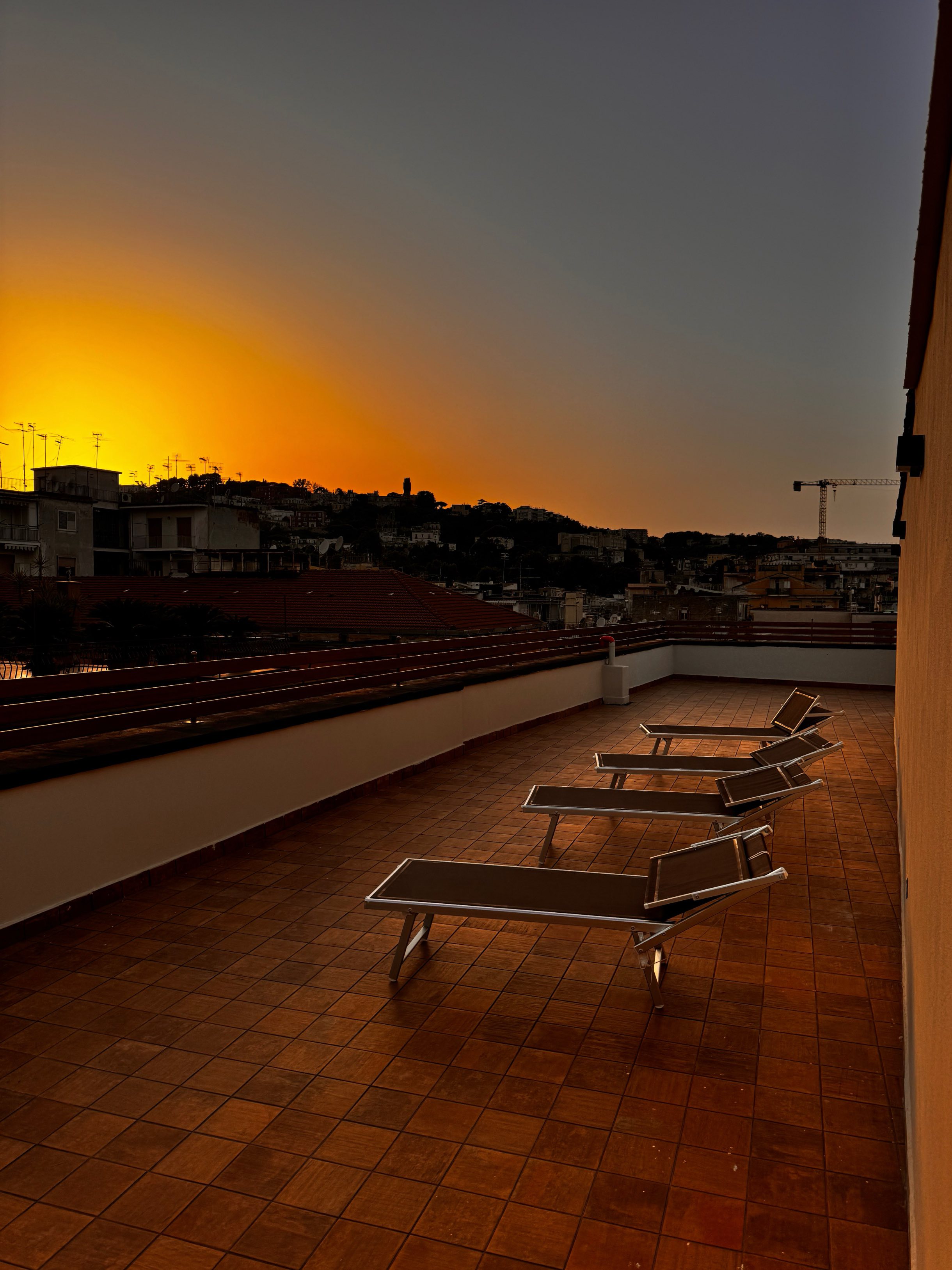 Terrazzo panoramico al tramonto con vista sui tetti di Napoli